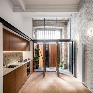 Ejemplo de cocina lineal, contemporánea, de tamaño medio, sin isla, con armarios con paneles lisos, puertas de armario marrones, suelo de baldosas de terracota, suelo rojo, fregadero de un seno, salpicadero marrón y electrodomésticos negros