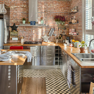 Inspiration för stora industriella kök, med en nedsänkt diskho, släta luckor, skåp i rostfritt stål, träbänkskiva, rostfria vitvaror, mellanmörkt trägolv och en köksö