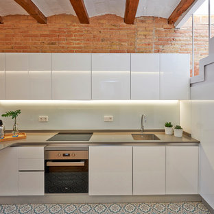 Foto de cocina mediterránea con fregadero de un seno, armarios con paneles lisos, puertas de armario blancas, salpicadero blanco, electrodomésticos de acero inoxidable, península, suelo multicolor y encimeras grises