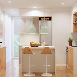 Imagen de cocina en U, nórdica, pequeña, con fregadero bajoencimera, puertas de armario de madera clara, salpicadero blanco, electrodomésticos de acero inoxidable, suelo de madera en tonos medios, una isla, encimeras blancas, armarios con paneles lisos y suelo beige