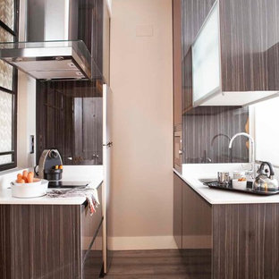 Foto de cocina de galera, contemporánea, pequeña, con armarios con paneles lisos, puertas de armario marrones, suelo de madera oscura y encimeras blancas