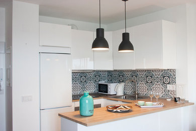 Diseño de cocinas en U escandinavo pequeño abierto con puertas de armario blancas, electrodomésticos blancos, suelo de baldosas de porcelana y suelo beige