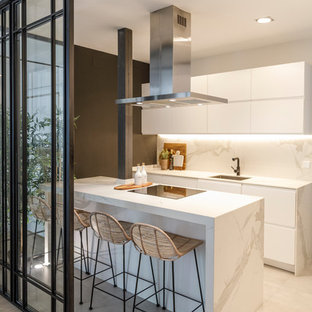 Foto de cocina de galera, contemporánea, cerrada, con fregadero bajoencimera, armarios con paneles lisos, puertas de armario blancas, una isla, suelo beige y encimeras blancas
