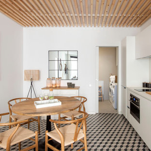 Imagen de cocina comedor lineal, nórdica, sin isla, con fregadero bajoencimera, armarios con paneles lisos, puertas de armario blancas, electrodomésticos de acero inoxidable, suelo multicolor y encimeras blancas
