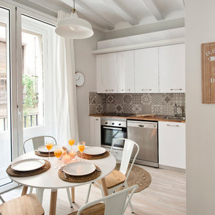 Foto de cocina comedor lineal, clásica renovada, pequeña, sin isla, con armarios con paneles lisos, puertas de armario blancas, encimera de madera, salpicadero multicolor, salpicadero de azulejos de cerámica, electrodomésticos de acero inoxidable, suelo de madera clara, suelo beige y fregadero encastrado