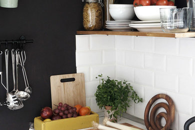 Bild på ett litet minimalistiskt parallellkök, med en enkel diskho, vita skåp, laminatbänkskiva, vitt stänkskydd, stänkskydd i terrakottakakel, vita vitvaror och grått golv
