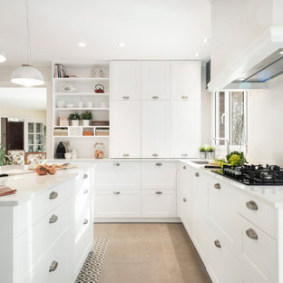 Diseño de cocina en L, contemporánea, de tamaño medio, cerrada, con fregadero bajoencimera, armarios estilo shaker, puertas de armario blancas, electrodomésticos con paneles, suelo de baldosas de porcelana, una isla, suelo beige y encimeras blancas