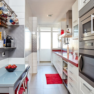 Mid-sized contemporary single-wall separate kitchen in Madrid with a double-bowl sink, raised-panel cabinets, white cabinets, quartz benchtops, grey splashback, ceramic splashback, stainless steel appliances, porcelain floors, no island, grey floor and red benchtop.