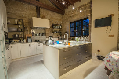 Diseño de cocinas en L rural de tamaño medio abierta con armarios con paneles con relieve, puertas de armario blancas y suelo de baldosas de cerámica