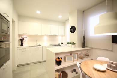 Inspiration pour une cuisine ouverte parallèle design de taille moyenne avec un placard à porte plane, des portes de placard blanches, une crédence blanche et une péninsule.