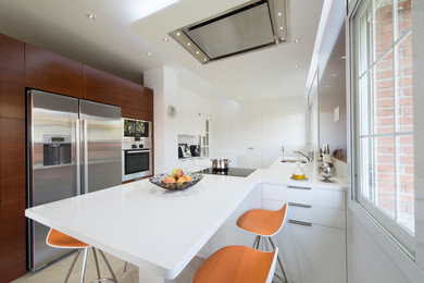 Modelo de cocina lineal minimalista extra grande abierta con armarios con paneles lisos, puertas de armario blancas y península