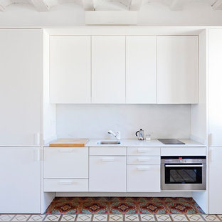 Foto de cocina lineal, mediterránea, pequeña, sin isla, con fregadero de un seno, armarios con paneles lisos, encimera de mármol, salpicadero blanco, salpicadero de mármol, suelo de azulejos de cemento, encimeras blancas, puertas de armario blancas, electrodomésticos de acero inoxidable y suelo multicolor