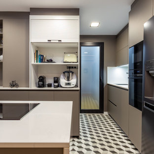 Diseño de cocina en U, actual, de tamaño medio, con armarios con paneles lisos, puertas de armario grises, salpicadero blanco, electrodomésticos negros, península, suelo multicolor y encimeras blancas