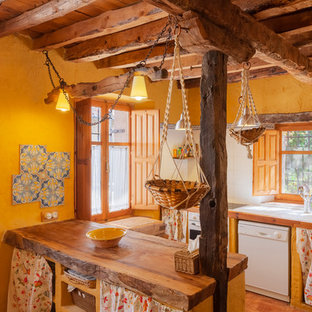 Imagen de cocina campestre con fregadero encastrado, puertas de armario de madera oscura, encimera de madera, salpicadero de vidrio, electrodomésticos blancos y península