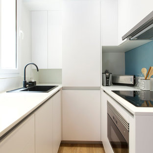 Diseño de cocina en U, actual, pequeña, abierta, sin isla, con armarios con paneles lisos, puertas de armario blancas, encimeras blancas, encimera de cuarzo compacto, salpicadero blanco, salpicadero de mármol, electrodomésticos con paneles, suelo de madera en tonos medios, suelo marrón y fregadero encastrado