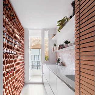 Inspiration for a mid-sized scandinavian single-wall open plan kitchen in Valencia with a single-bowl sink, louvered cabinets, beige cabinets, stainless steel benchtops, multi-coloured splashback, cement tile splashback, panelled appliances, ceramic floors, no island, grey floor and white benchtop.