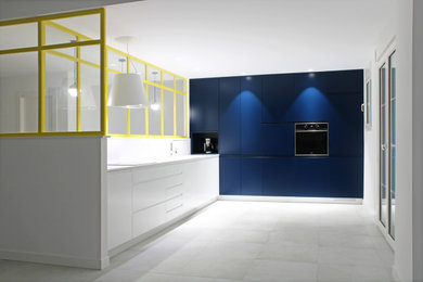 Imagen de cocinas en L moderna grande abierta con fregadero de un seno, armarios con paneles lisos, puertas de armario azules, salpicadero blanco, suelo gris y encimeras blancas