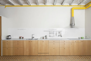 バルセロナにあるインダストリアルスタイルのおしゃれなI型キッチン (ダブルシンク、フラットパネル扉のキャビネット、淡色木目調キャビネット、白いキッチンパネル、アイランドなし、マルチカラーの床、白いキッチンカウンター) の写真