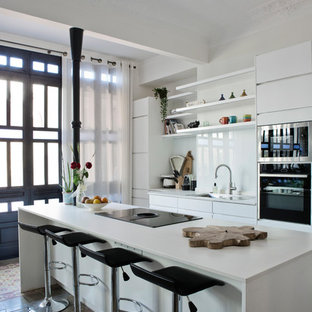 Modelo de cocina nórdica con encimera de cuarzo compacto, salpicadero de vidrio, encimeras blancas, armarios con paneles lisos, puertas de armario blancas, salpicadero blanco y una isla