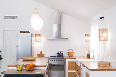 Offene Mediterrane Küche mit Doppelwaschbecken, Arbeitsplatte aus Holz, Rückwand aus Keramikfliesen, Keramikboden, Kücheninsel und grauem Boden in Sonstige