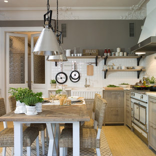 Modelo de cocina comedor en L, de estilo de casa de campo, de tamaño medio, sin isla, con armarios con paneles lisos, puertas de armario de madera oscura, salpicadero blanco, electrodomésticos blancos, suelo beige y fregadero sobremueble