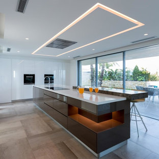 Diseño de cocina contemporánea, extra grande, con armarios con paneles lisos, puertas de armario marrones, una isla, encimeras blancas, fregadero de un seno y suelo beige