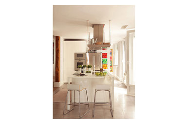 マドリードにある中くらいなカントリー風のおしゃれなキッチン (フラットパネル扉のキャビネット、白いキャビネット、セラミックタイルの床) の写真