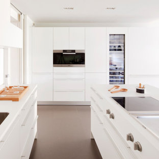 Foto de cocina en U, contemporánea, de tamaño medio, con fregadero bajoencimera, armarios con paneles lisos, puertas de armario blancas, encimera de acrílico, suelo de baldosas de porcelana, una isla, suelo marrón y encimeras blancas
