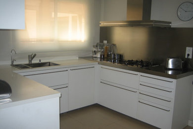 Foto de cocinas en U actual pequeño cerrado sin isla con armarios con paneles lisos y puertas de armario blancas