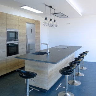 Ejemplo de cocina contemporánea, pequeña, con puertas de armario de madera clara, encimera de granito, suelo de baldosas de cerámica, una isla, suelo gris, fregadero de un seno, armarios con paneles lisos, electrodomésticos de acero inoxidable y encimeras grises