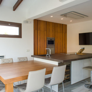 Modelo de cocina comedor contemporánea, grande, con fregadero integrado, armarios con paneles lisos, encimera de granito, salpicadero verde, salpicadero de losas de piedra, electrodomésticos de acero inoxidable, suelo de mármol, dos o más islas y suelo blanco