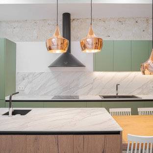 Foto de cocina de galera, contemporánea, con fregadero encastrado, armarios con paneles lisos, puertas de armario verdes, electrodomésticos con paneles, una isla y encimeras blancas
