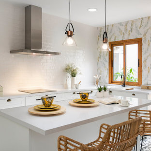 Diseño de cocina en L, actual, con fregadero encastrado, armarios estilo shaker, puertas de armario blancas, salpicadero blanco, salpicadero de azulejos de terracota, una isla, suelo multicolor y encimeras blancas