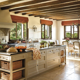 Foto de cocina comedor en L, mediterránea, grande, con fregadero bajoencimera, armarios estilo shaker, encimera de mármol, salpicadero de azulejos de cerámica, una isla, suelo marrón, encimeras grises, suelo de piedra caliza y puertas de armario beige