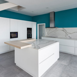 Ejemplo de cocina contemporánea, grande, abierta, con puertas de armario blancas, encimera de mármol, salpicadero blanco, salpicadero de azulejos de piedra, electrodomésticos blancos, una isla y encimeras blancas