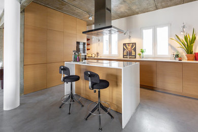 Foto de cocinas en L grande abierta con suelo de cemento, una isla y microcemento