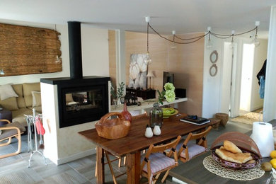 Modelo de comedor de estilo de casa de campo de tamaño medio abierto con paredes multicolor, chimenea de doble cara y marco de chimenea de metal
