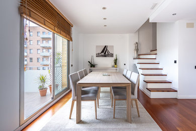 Design ideas for a medium sized scandi open plan dining room in Barcelona with white walls, medium hardwood flooring, brown floors and no fireplace.