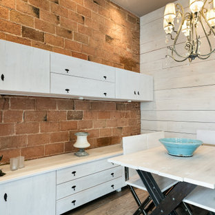 Ejemplo de comedor urbano, sin chimenea, con paredes beige y suelo de madera en tonos medios