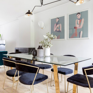 Imagen de comedor actual con paredes blancas, suelo de madera clara y suelo beige
