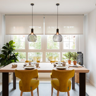 Imagen de comedor contemporáneo con paredes blancas y suelo gris
