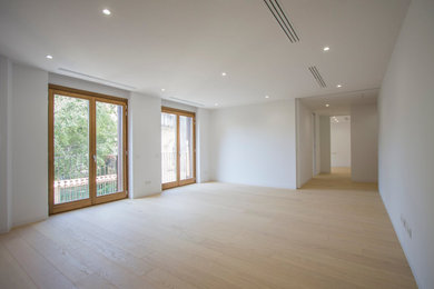 Ejemplo de comedor minimalista de tamaño medio cerrado con paredes blancas y suelo de madera clara