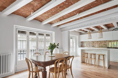 Light wood floor and beige floor dining room photo in Barcelona with white walls