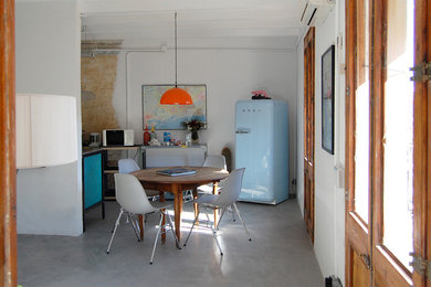 Modelo de comedor de cocina contemporáneo de tamaño medio con paredes blancas y suelo de cemento