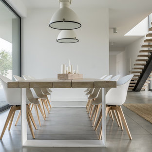 Foto de comedor minimalista, grande, con paredes blancas, suelo de cemento y suelo gris