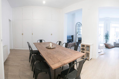 Inspiration pour une salle à manger ouverte sur le salon nordique de taille moyenne avec un mur blanc, parquet clair et une cheminée standard.