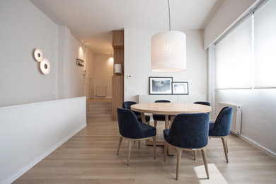 Imagen de comedor contemporáneo de tamaño medio abierto con paredes blancas, suelo de madera clara y suelo beige