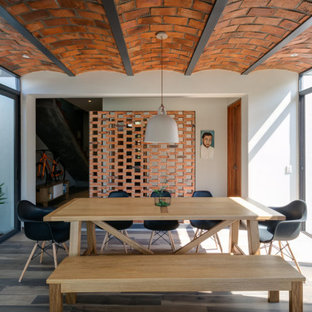 Imagen de comedor actual con paredes blancas, suelo de madera oscura y suelo marrón