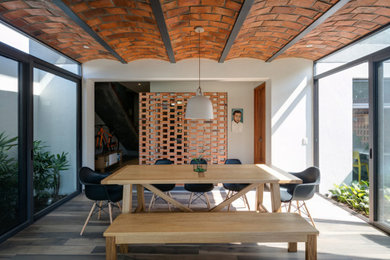 Imagen de comedor actual con paredes blancas, suelo de madera oscura y suelo marrón