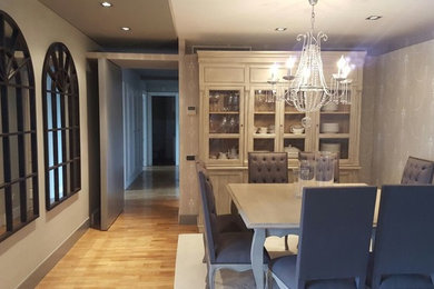 Esempio di una sala da pranzo aperta verso il soggiorno chic di medie dimensioni con pareti grigie, parquet chiaro e pavimento beige